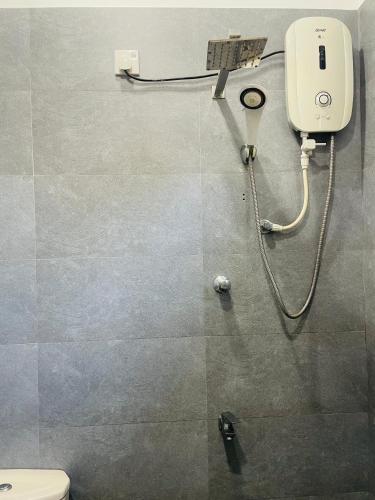 a bathroom with a toilet and a soap dispenser on the wall at Serandib Town Apartment in Weligama