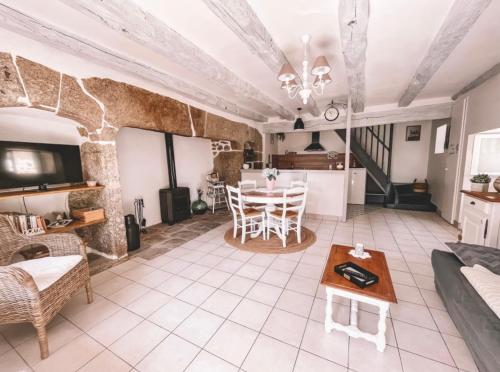 a living room with a table and a kitchen at Le coin des Samariens - Étape Saint-Jacques in Golinhac