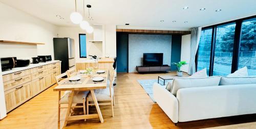 a living room with a white couch and a table at Akikawa Koshi 9 プレミアム鉄骨 一棟貸切ヴィラ in Yuge