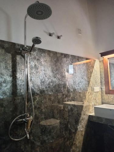 a shower stall in a bathroom with a sink at Villa Nuelumalee UpStairs in Hikkaduwa