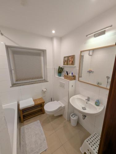 a white bathroom with a sink and a toilet at Ferienwohnung Erlengrund in Mochenwangen