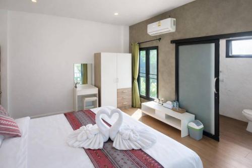a bedroom with two white swans on a bed at River Bend Villas in Mae Rim