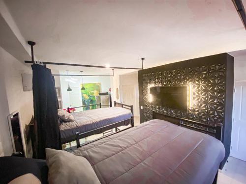 a bedroom with two beds and a large window at Baja Cabo Hostal Arenal in Cabo San Lucas