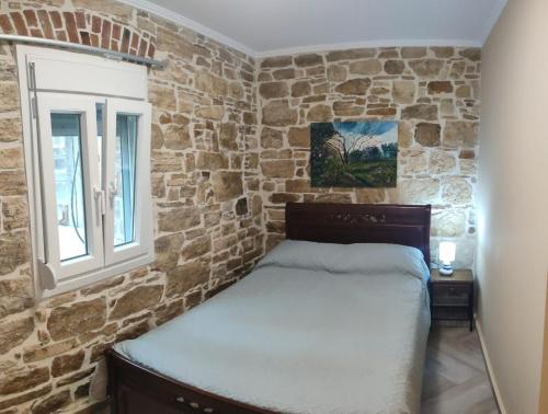 a bedroom with a stone wall with a bed at Villa Kalliope in Nénita