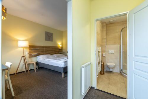 a hotel room with a bed and a bathroom at Penzion Rodos - Café in Prague