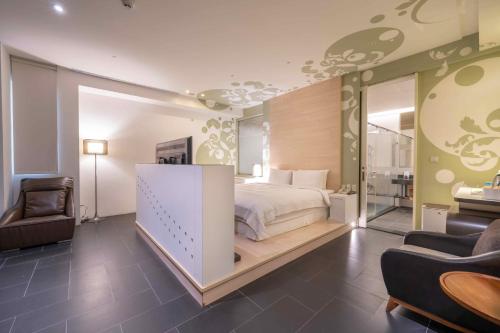 ein Schlafzimmer mit einem Bett, einer Couch und einem Stuhl in der Unterkunft No. 9 Hotel in Jiaoxi