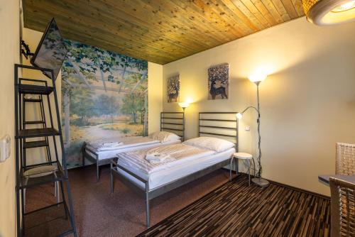two beds in a room with a painting on the wall at Penzion Rodos - Café in Prague