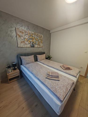 a bedroom with a bed with two towels on it at Apartman Amber Vrnjačka Banja in Vrnjačka Banja