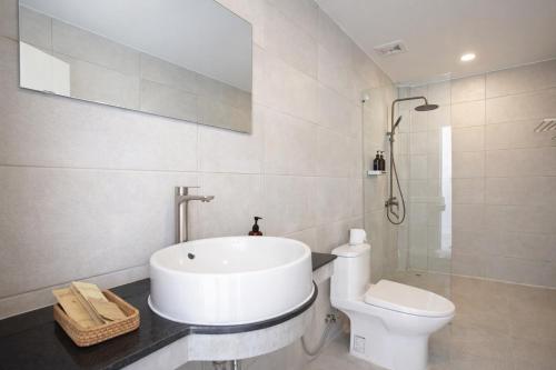 a white bathroom with a sink and a toilet at Le Baoli Koh Rong in Phumĭ Kaôh Rŏng