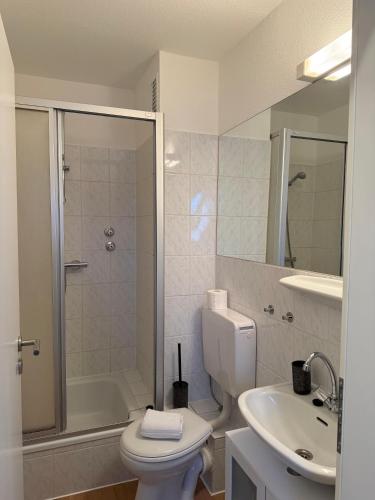 a bathroom with a toilet and a sink and a shower at Nordhavn in Harrislee