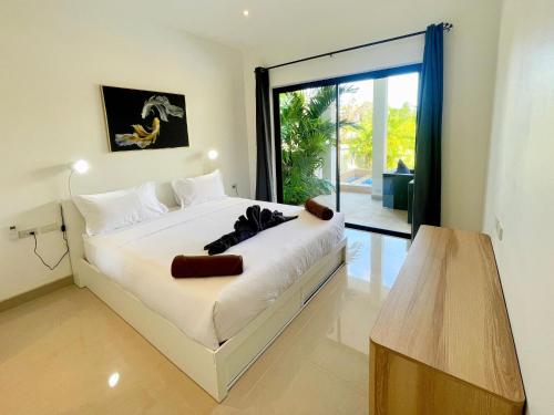 a bedroom with a bed and a large window at Thala Villa Koh Samui in Nathon Bay