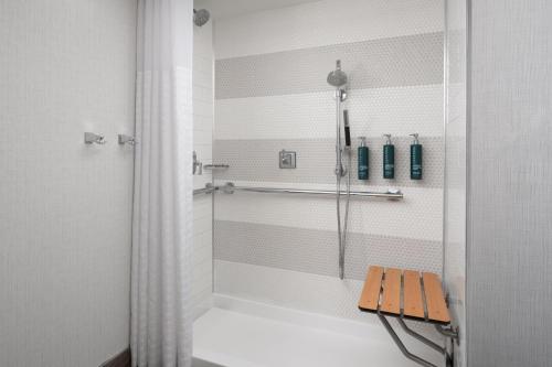 a shower with a bench in a bathroom at DoubleTree by Hilton Gainesville in Gainesville