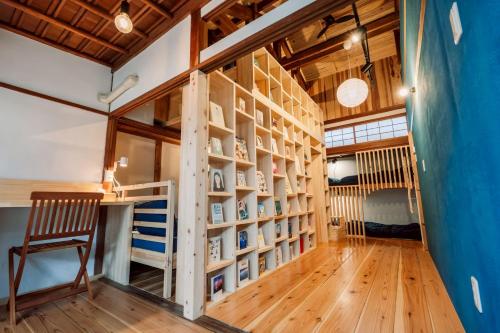a room with a book shelf and a desk at うみの図書館 in Sanuki