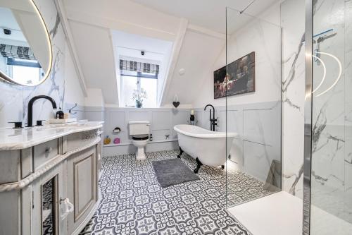a bathroom with a tub and a sink and a toilet at Old Rectory Cottage, Tostock in Tostock