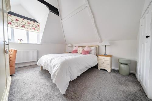 a bedroom with a bed with pink stuffed animals on it at Old Rectory Cottage, Tostock in Tostock
