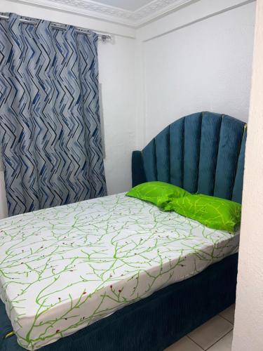 una camera da letto con un letto e una sedia blu di Eleins prestige a Douala