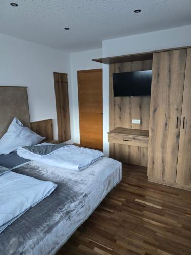 a bedroom with two beds and a flat screen tv at Haus Levi in Imst