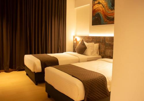 a hotel room with two beds in a room at Magnus Lxia Premier, Kalyani Nagar Pune in Pune