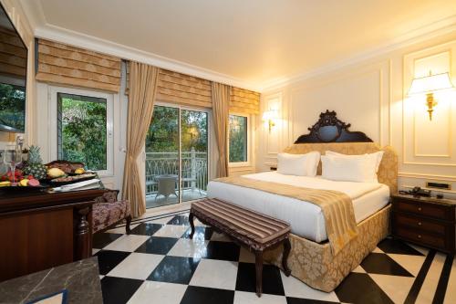 a bedroom with a bed and a desk and windows at Ali Bey Resort Sorgun in Side