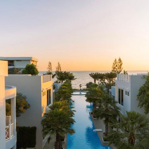 an aerial view of a resort with a pool and the ocean at The Delfini Hua Hin in Hua Hin