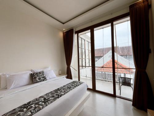 a bedroom with a large bed and a large window at Ramady Guest House in Tumbak Bayuh