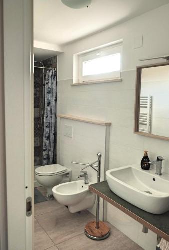a bathroom with two sinks and a toilet at Casa Verde Oliva - WelcHome in Rocca San Giovanni