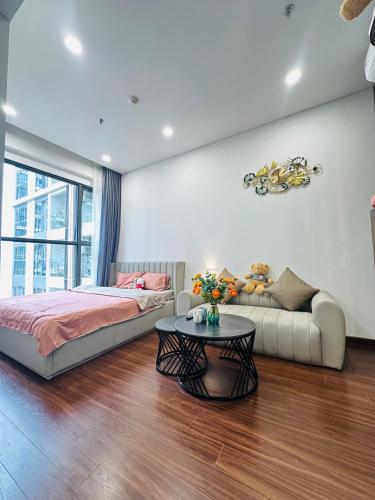 a bedroom with a bed and a couch and a table at M2 Homestay vinhomes ocean in Gia Lâm Pho