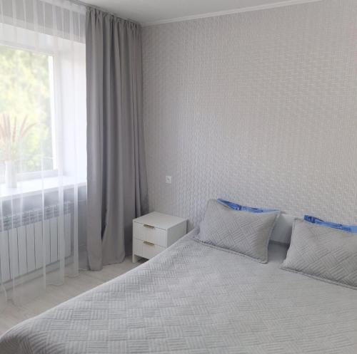 a bedroom with a large bed with a window at Aizhan Bekshenova in Lenīnogorsk