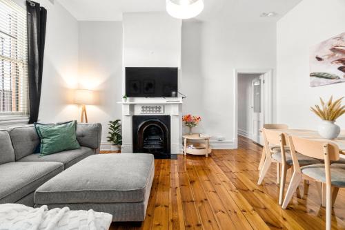 a living room with a couch and a table at The Arches-Beautiful 3-Bedroom Family Stay Near Adelaide Oval, City Events and Amazing Dining in North Adelaide
