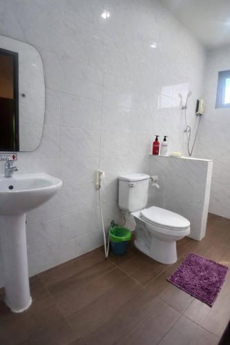 a bathroom with a white toilet and a sink at River Bend Villas in Mae Rim