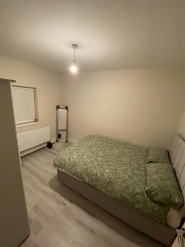 a bedroom with a bed with a green comforter at Big Town Charm in Drogheda