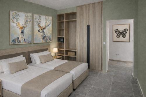 a bedroom with two beds and a butterfly painting on the wall at Maritina Apartments in Ixia