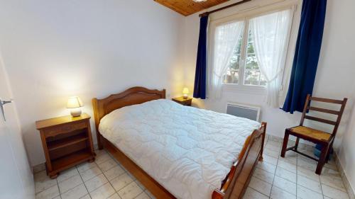 a bedroom with a bed and a chair and a window at Villa des Oceanides in Saint-Gilles-Croix-de-Vie