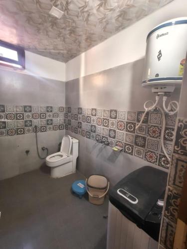 a small bathroom with a toilet and a sink at Hotel Yamuna palace in Kharsālī