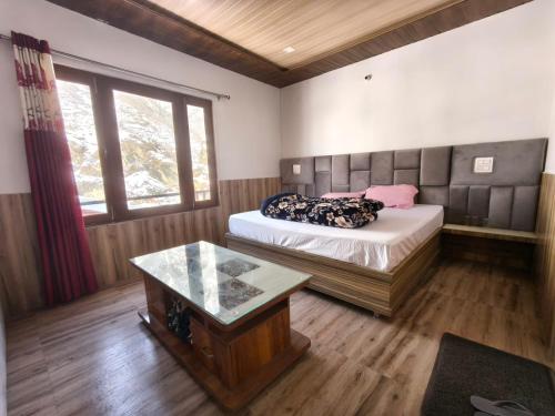 a bedroom with a bed and a table in it at Hotel Yamuna palace in Kharsālī