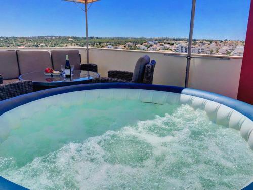 a hot tub on a balcony with a table at Apartment Beta - 2 Bedrooms, Private Rooftop Patio with Hot Tub, BBQ and View in Ferragudo