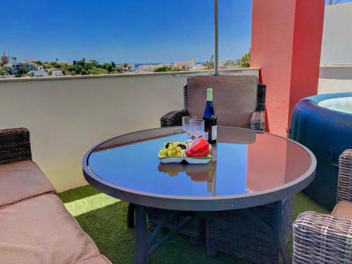 a table with a bottle of wine and a plate of fruit at Apartment Beta - 2 Bedrooms, Private Rooftop Patio with Hot Tub, BBQ and View in Ferragudo