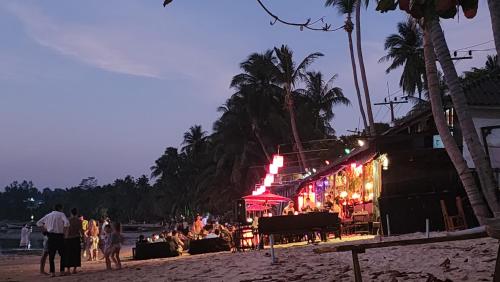 a group of people walking on a beach at night at Feel home Private Studio in Ko Phangan