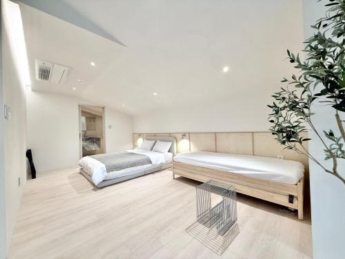 a bedroom with two beds and a table at FORESTE Haus 포레스테하우스 in Seoul