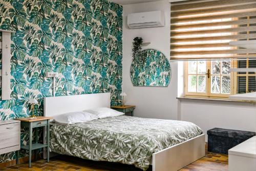 a bedroom with a bed and a blue and white wallpaper at Mary Jungle in Porto SantʼElpidio