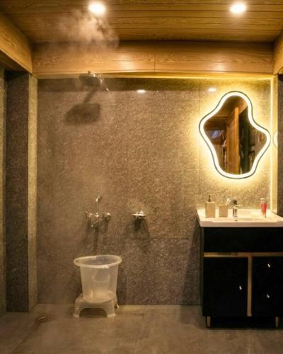 a bathroom with a toilet and a sink at Bawli Treehouse Duplex, Jibhi in Jibhi