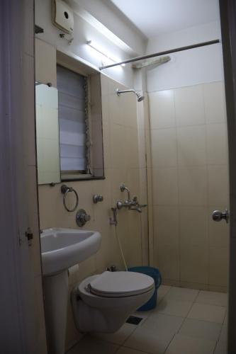a bathroom with a toilet and a sink and a shower at Hotel krishnasai in Pune