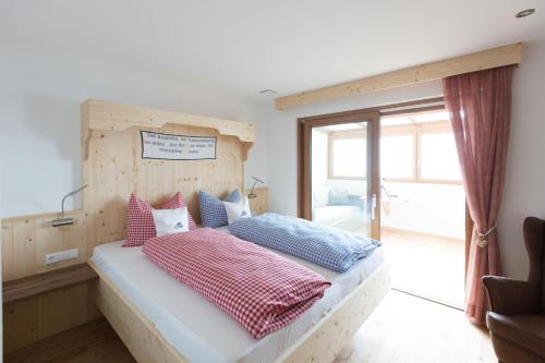 a bedroom with a bed with a wooden headboard at Unterthurnerhof in Rifiano