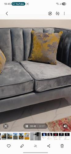 a grey couch with a yellow pillow on it at Lins Haven in Kilifi