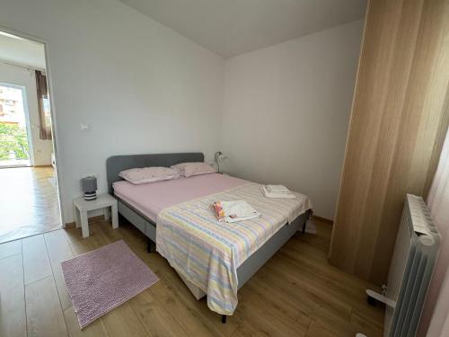 a bedroom with a bed with a stuffed animal on it at Apartmani Luce in Zadar