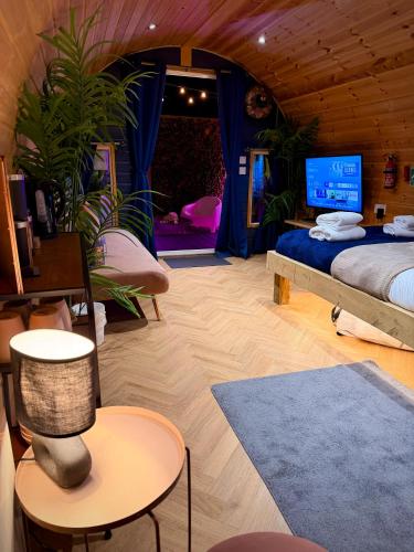 a bedroom with a bed and a tv in it at The Secret Garden Glamping Lancashire in Skelmersdale
