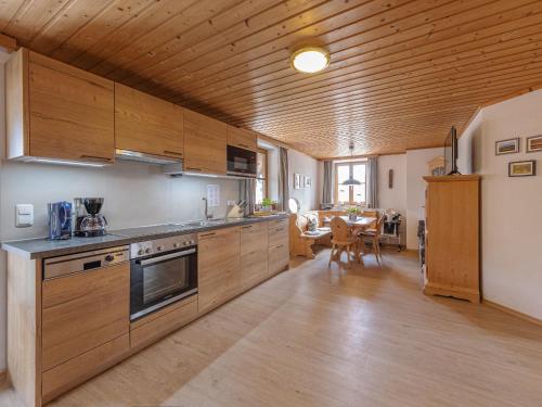 a kitchen with wooden cabinets and a dining room at Sailerhof Gramminger in Taching am See