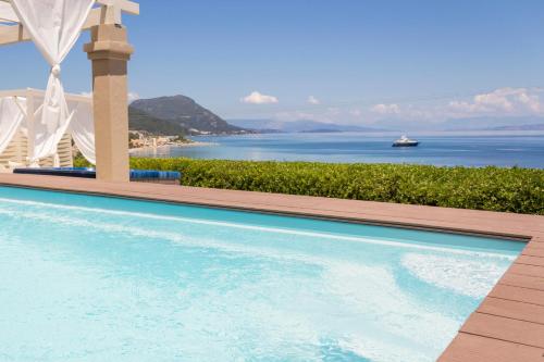 a swimming pool with a view of the ocean at Palms and Spas Villas Retreat in Mesongi