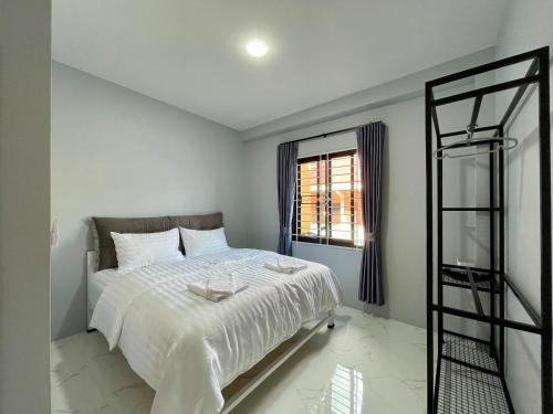 a bedroom with a white bed and a window at Angie Tiny House near Krabi Airport with Free Airport Shuttle