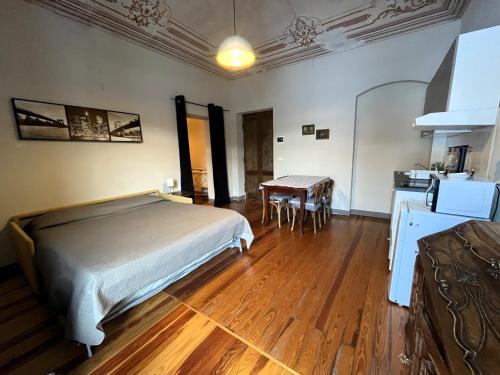 a bedroom with a bed and a table and a kitchen at La Fornace in Garessio
